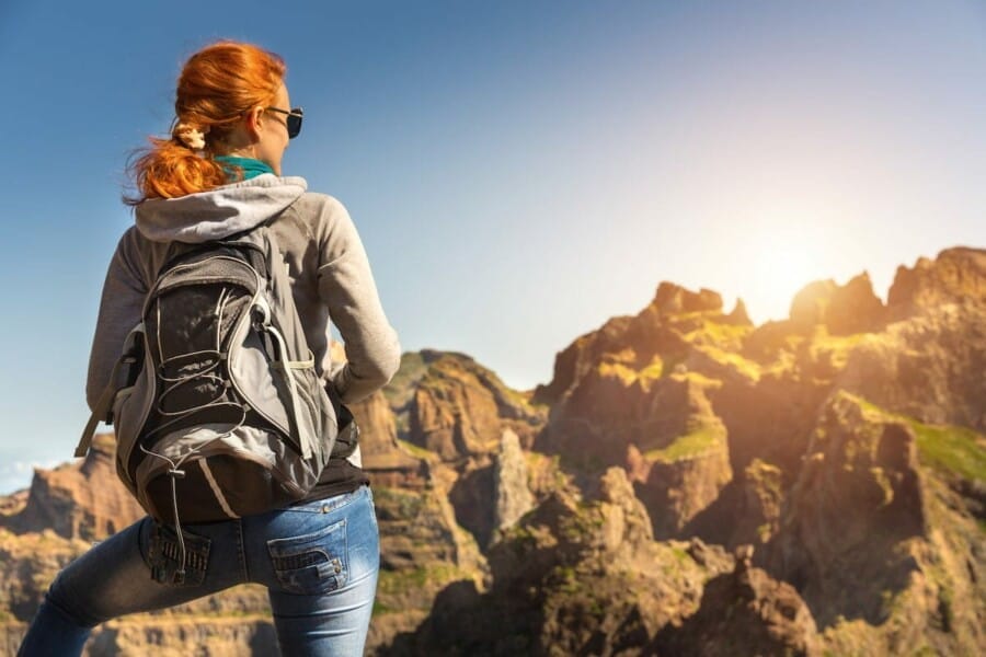 A woman hiker on tip of the mountain on a sunrise.